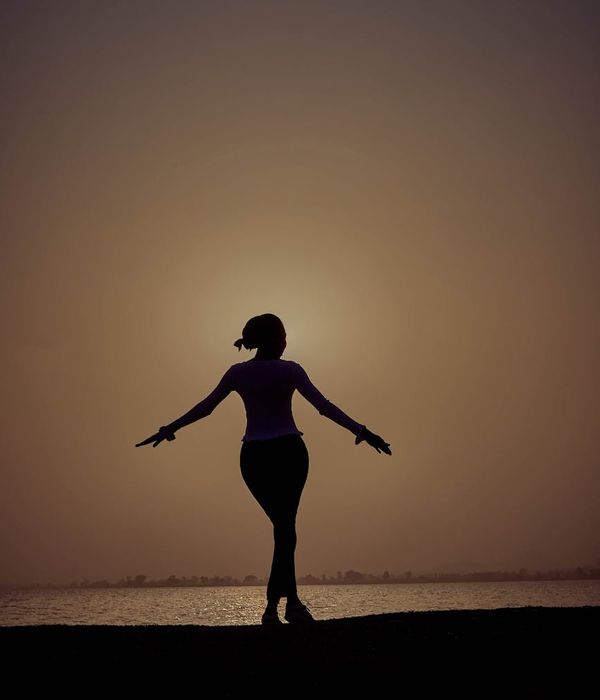Woman in a calm yoga pose in a dark, atmospheric setting.